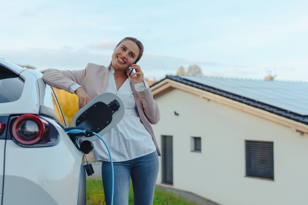 woman using solar power to charge her electric vehicle